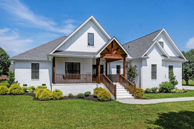 view of front of house featuring covered porch and a front lawn