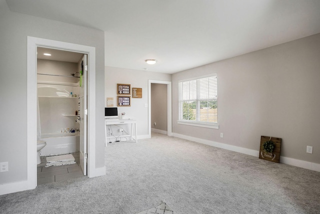 interior space with ensuite bathroom and carpet flooring