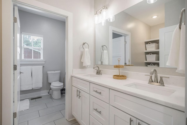 bathroom featuring toilet, tile patterned flooring, and vanity