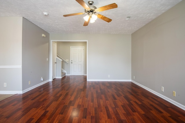 empty room featuring dark hardwood / wood-style flooring, a textured ceiling, and ceiling fan