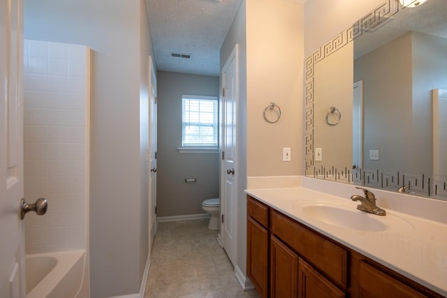 bathroom featuring toilet, vanity, and a textured ceiling