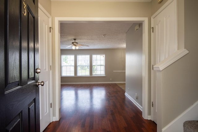 foyer entrance featuring a textured ceiling, ceiling fan, and dark hardwood / wood-style flooring