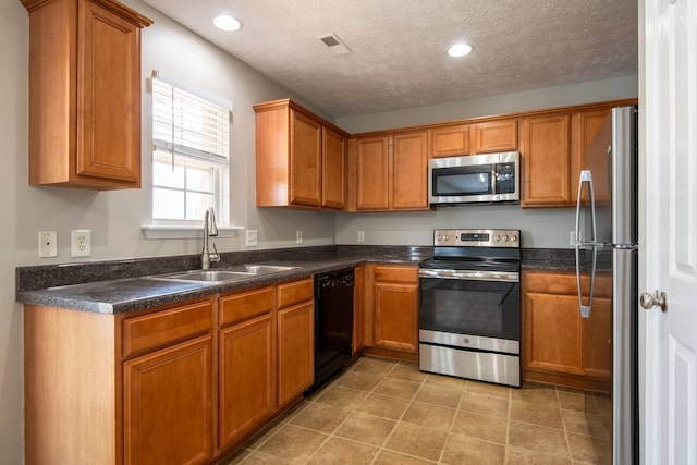 kitchen with sink, stainless steel appliances, and a textured ceiling