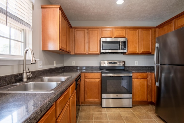 kitchen with sink, a textured ceiling, and appliances with stainless steel finishes