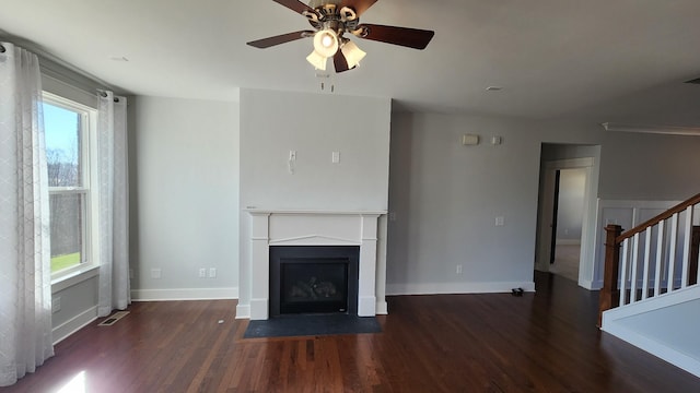 unfurnished living room featuring ceiling fan, dark hardwood / wood-style flooring, and a wealth of natural light