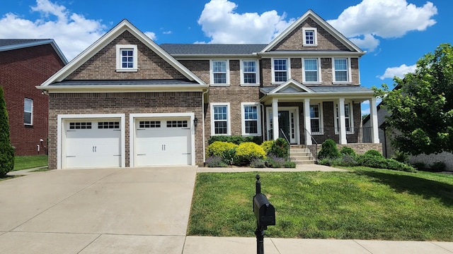 craftsman-style home featuring covered porch, a garage, and a front yard