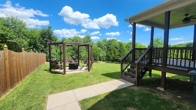 view of yard featuring a deck, ceiling fan, and a patio area