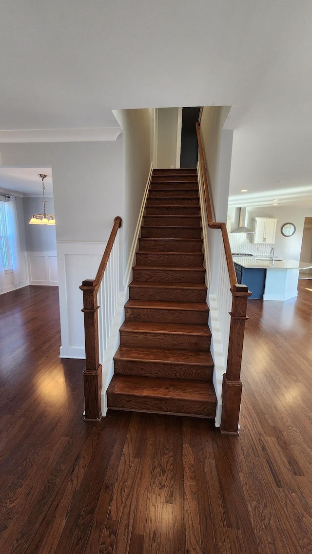 stairway with hardwood / wood-style floors and sink