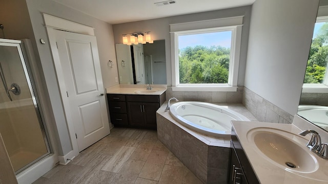 bathroom with plenty of natural light, independent shower and bath, and vanity