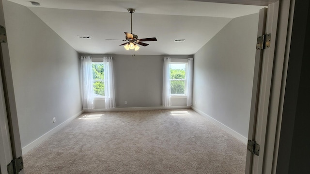 carpeted spare room with ceiling fan and lofted ceiling