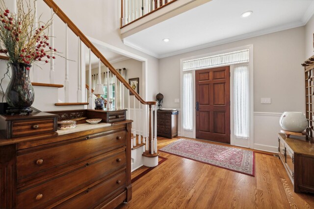 entryway with crown molding and light hardwood / wood-style flooring