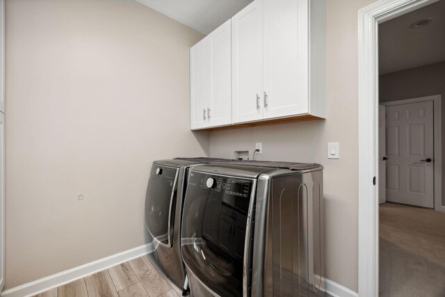 laundry area with light colored carpet, washer and dryer, cabinets, and hookup for a washing machine