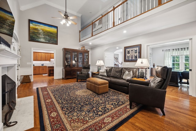 living room with high vaulted ceiling, light hardwood / wood-style floors, and ceiling fan