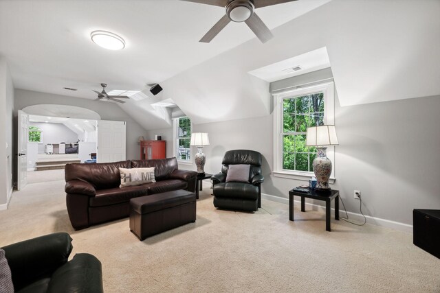 carpeted living room with ceiling fan and lofted ceiling