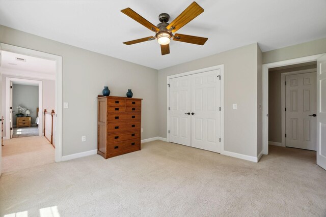 unfurnished bedroom featuring ceiling fan, a closet, and light carpet