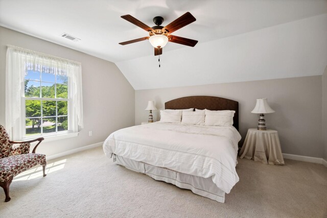 bedroom with ceiling fan, lofted ceiling, and light carpet