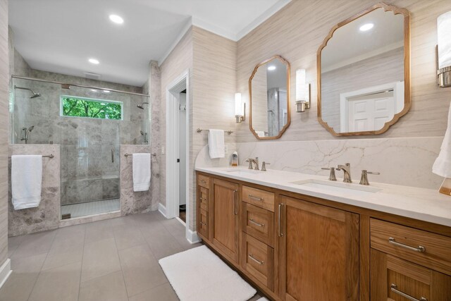 bathroom with tile walls, a shower with door, dual vanity, and tile flooring