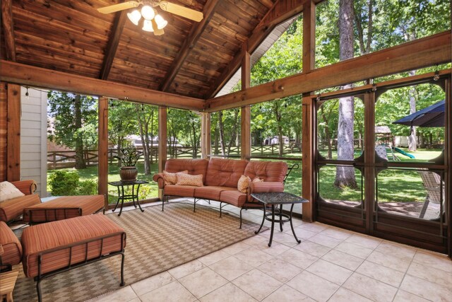 sunroom with plenty of natural light, ceiling fan, lofted ceiling with beams, and wood ceiling