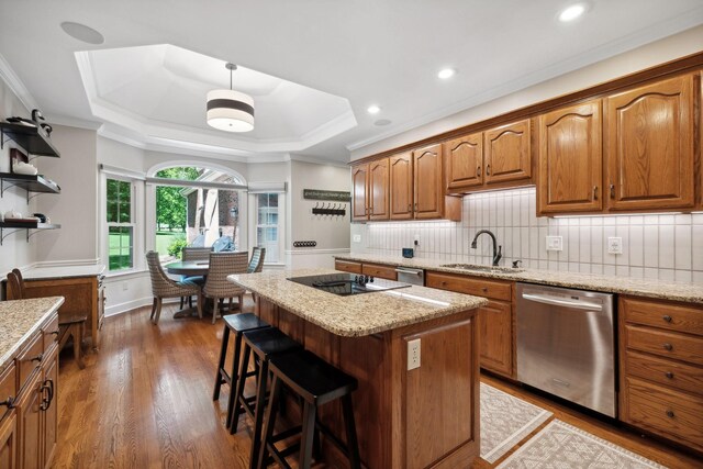 kitchen with a kitchen island, dishwasher, tasteful backsplash, hardwood / wood-style flooring, and sink