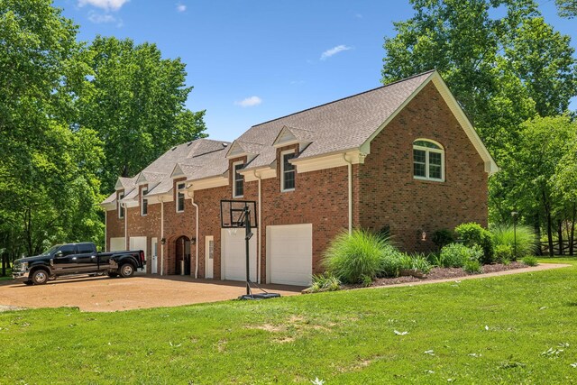 view of side of property featuring a garage and a lawn