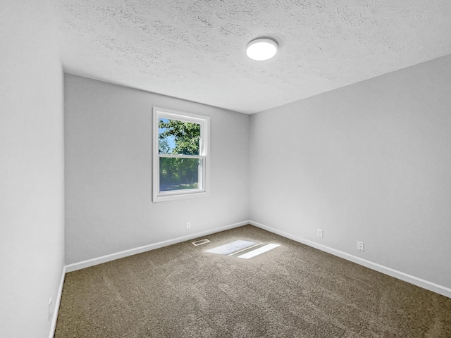 carpeted empty room with a textured ceiling