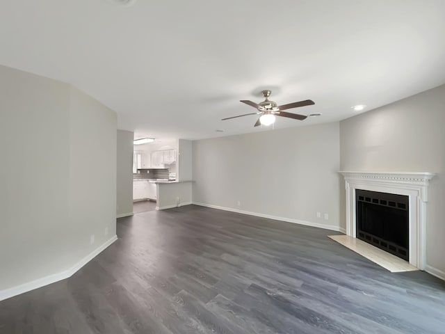 unfurnished living room with ceiling fan and dark wood-type flooring