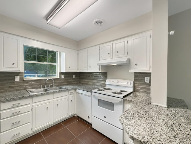 kitchen featuring backsplash, white appliances, sink, dark tile patterned flooring, and white cabinetry