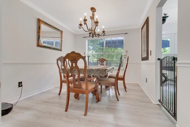 dining room featuring light wood-type flooring, a chandelier, and ornamental molding