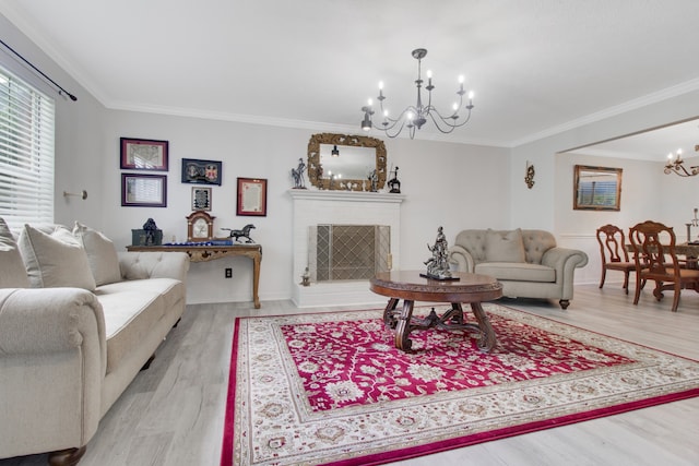 living room featuring light wood-type flooring, a notable chandelier, and ornamental molding