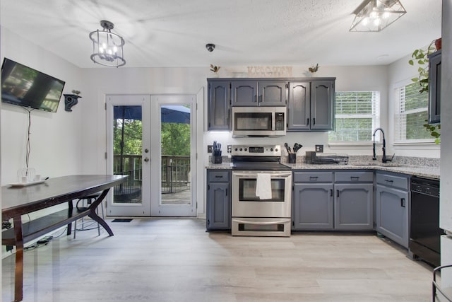 kitchen with a chandelier, french doors, appliances with stainless steel finishes, light hardwood / wood-style floors, and sink