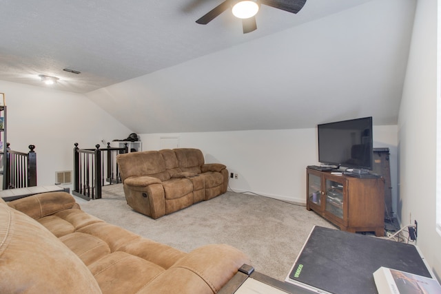 carpeted living room with ceiling fan, vaulted ceiling, and a textured ceiling