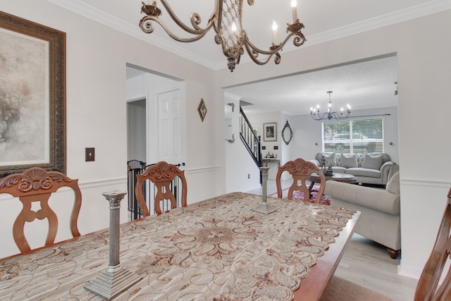 dining room with light wood-type flooring, crown molding, and a chandelier