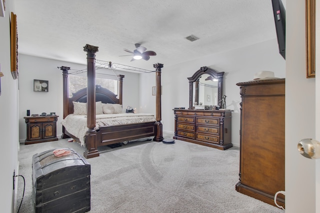 bedroom with ceiling fan, a textured ceiling, and carpet floors