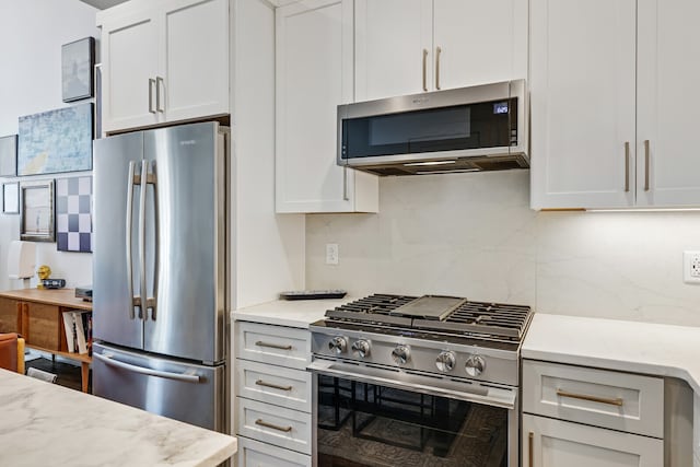 kitchen featuring stainless steel appliances, light stone countertops, and tasteful backsplash