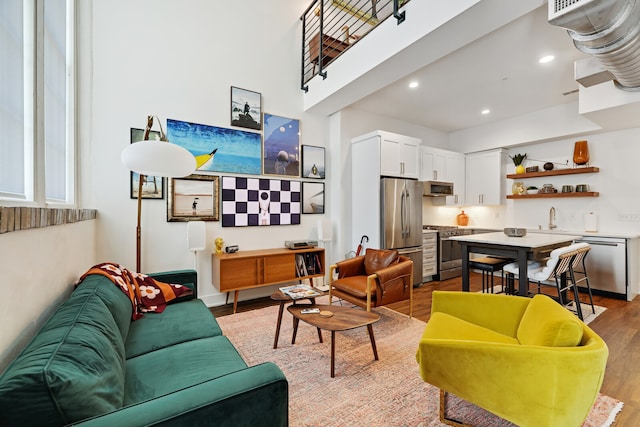 living room with sink and light hardwood / wood-style flooring