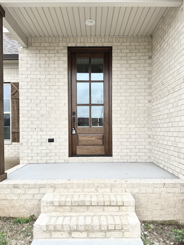 view of exterior entry featuring covered porch