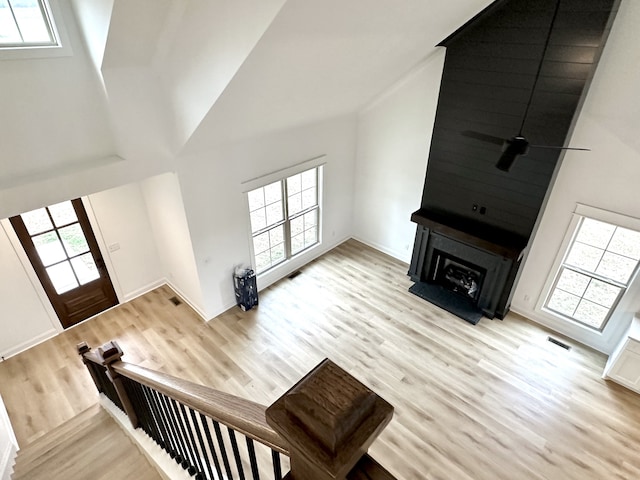 living room featuring high vaulted ceiling, a wealth of natural light, and light hardwood / wood-style flooring