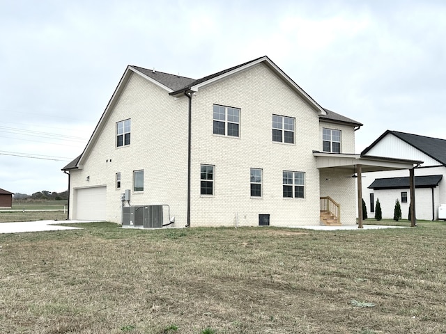 view of side of property with central AC unit, ceiling fan, a garage, and a yard