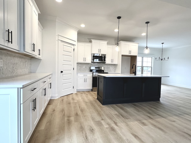 kitchen featuring white cabinets, pendant lighting, and appliances with stainless steel finishes