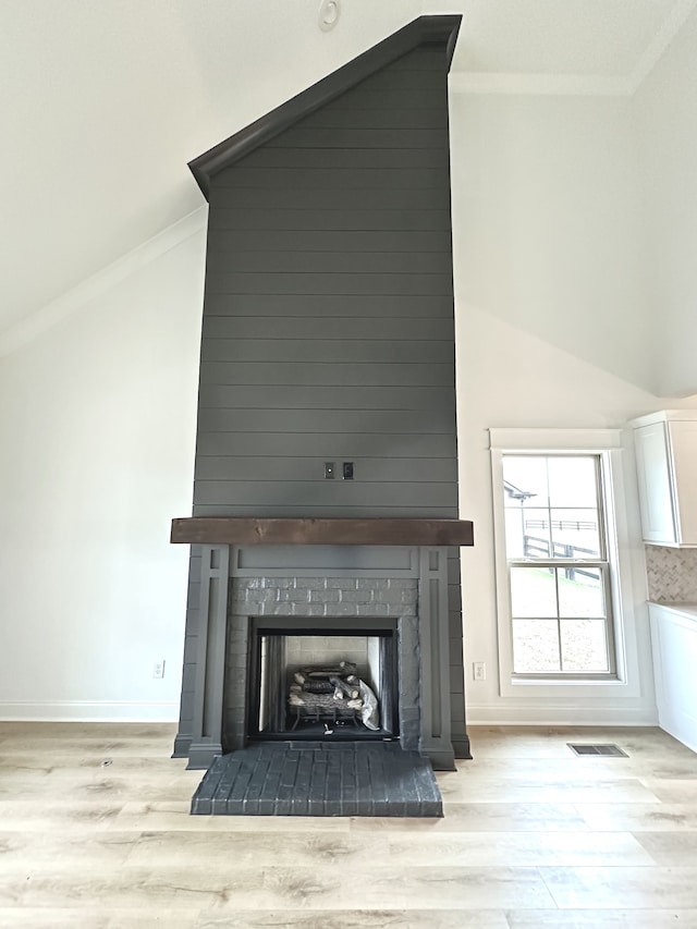 room details featuring crown molding, a fireplace, and wood-type flooring