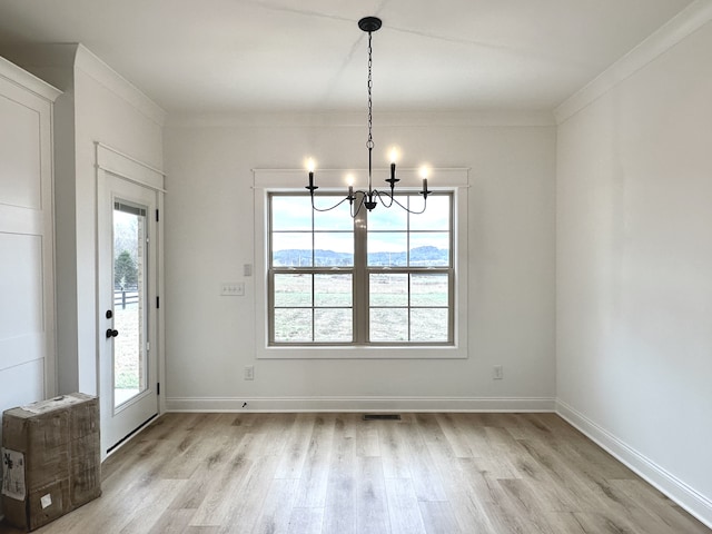 unfurnished dining area featuring light wood-type flooring, a healthy amount of sunlight, and a notable chandelier