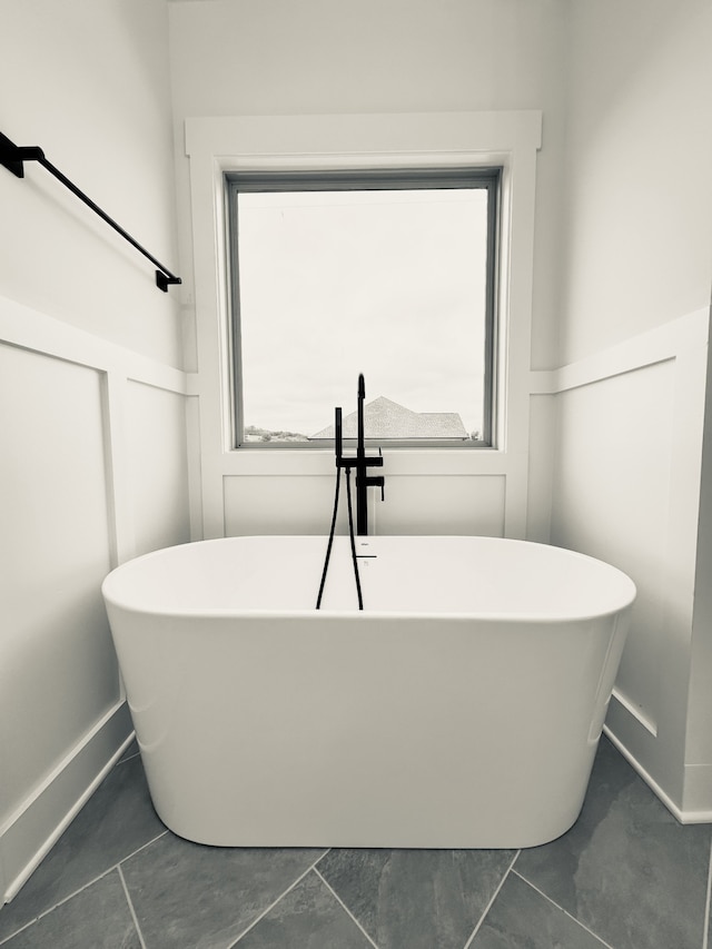 bathroom featuring a bathing tub, tile patterned floors, and a wealth of natural light