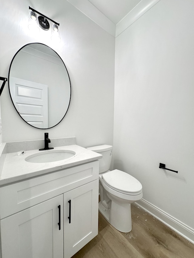 bathroom featuring toilet, vanity, and hardwood / wood-style flooring