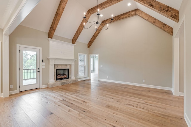 unfurnished living room featuring beam ceiling, a fireplace, high vaulted ceiling, and light hardwood / wood-style floors