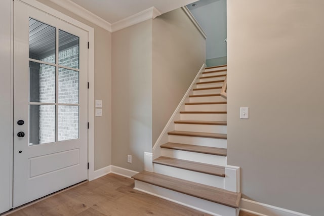 entryway featuring ornamental molding and light hardwood / wood-style flooring