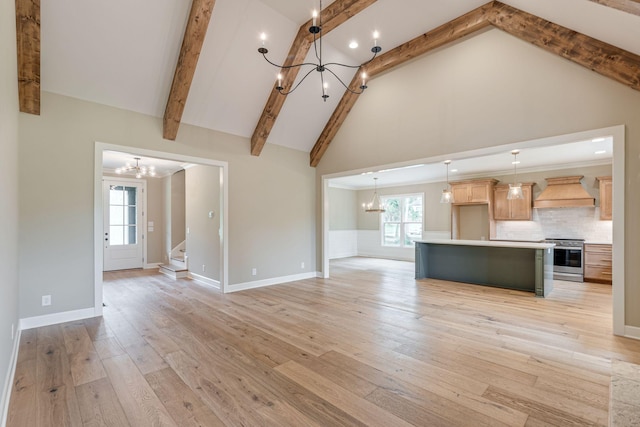 unfurnished living room featuring high vaulted ceiling, light wood-type flooring, and an inviting chandelier