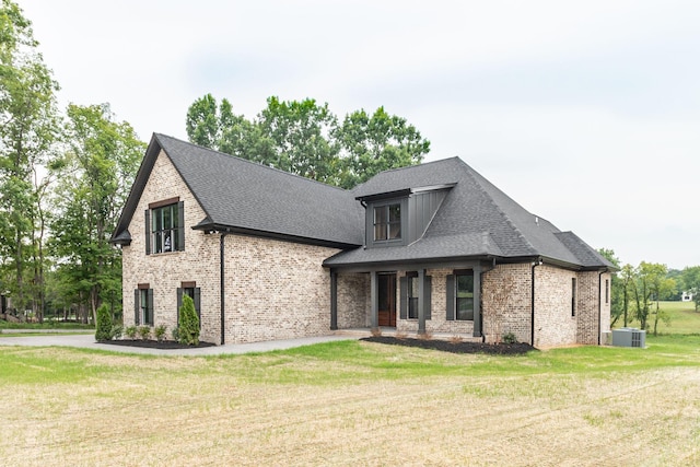 view of front of home with a front lawn and central air condition unit