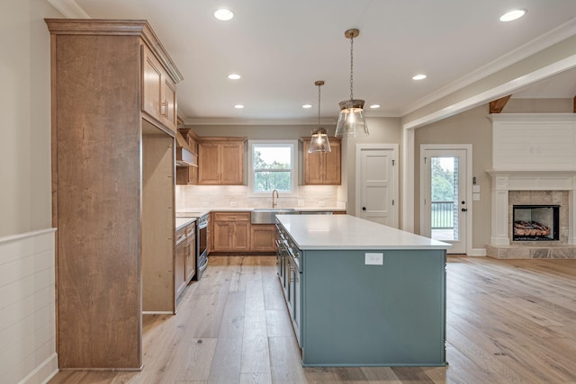 kitchen with hanging light fixtures, stainless steel electric range, light wood-type flooring, and a kitchen island