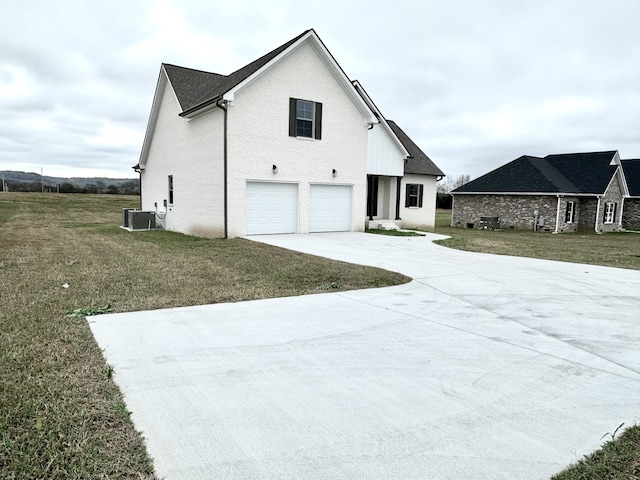 view of front of house featuring central AC, a front yard, and a garage