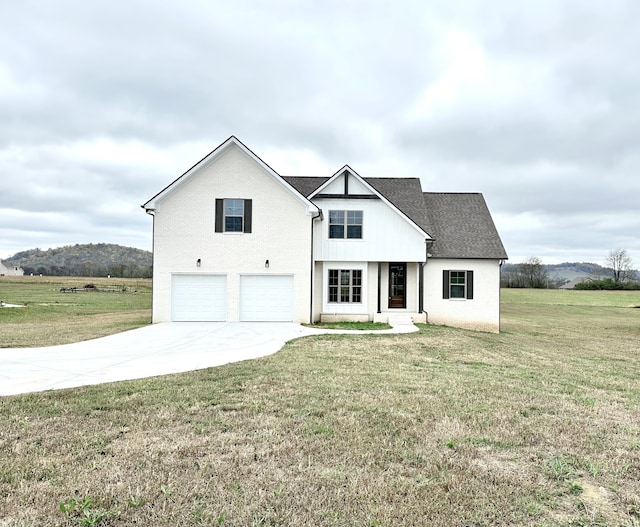 modern farmhouse style home with a mountain view, a garage, and a front lawn